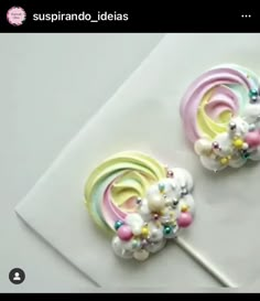 two candy lollipops are sitting on top of a white paper towel with beads