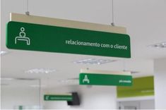 a green sign hanging from the ceiling in an office building that reads racionamamentoe com o cliente