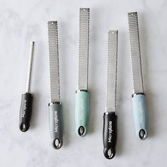 four different types of hair straighteners on a white counter top with the same one being used