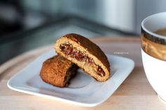 two cookies on a plate next to a cup of coffee