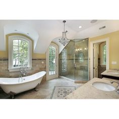 an elegant bathroom with claw foot tub and walk - in shower, double sinks, chandelier