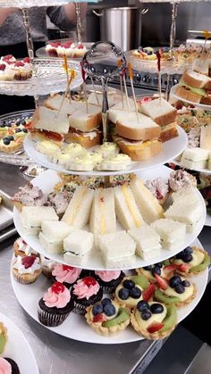 a table topped with lots of different types of sandwiches and cupcakes on top of plates