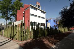 a tall white building sitting next to a green fence