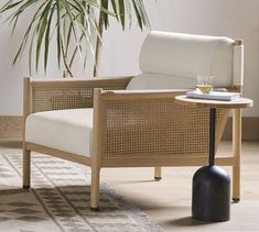 a living room with a chair, table and potted plant