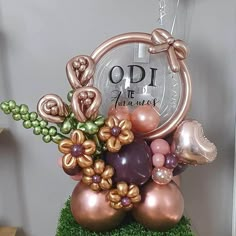 a vase filled with balloons and flowers on top of a green planter in front of a clock