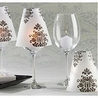 three wine glasses are sitting next to each other with candle holders on the side and napkins in front of them