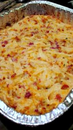 a casserole dish with cheese and bacon in it on a stove top, ready to be eaten