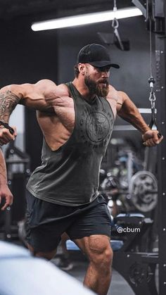 a man with a beard and no shirt is doing exercises in the gym while holding a barbell