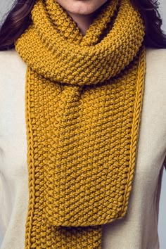 a woman wearing a yellow knitted scarf