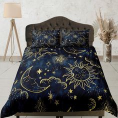 a bed covered in blue and gold stars and moon designs