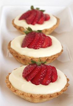 three small pastries with strawberries on them