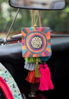 the interior of a car with colorful decorations hanging from it's side view mirror