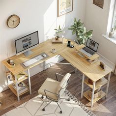 a computer desk with two laptops on it and a chair in front of it