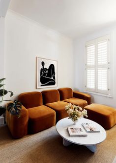 a living room filled with furniture and a painting on the wall