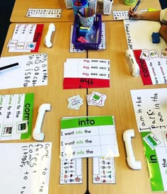 a wooden table topped with lots of different types of writing and paper on top of it