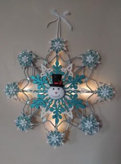 a snowflake hanging from the ceiling with lights around it and a light bulb in the center