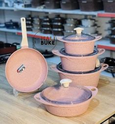 pink pots and pans are stacked on top of each other