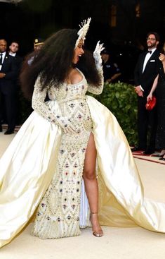 a woman in a white gown with long sleeves and high slit