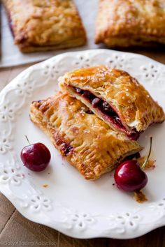 two pieces of pie on a plate with cherries