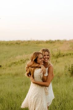 two women hugging each other in a field