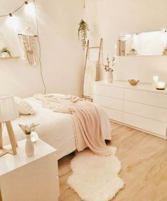 a bedroom with white furniture and lights on the wall above the bed is decorated in neutral colors