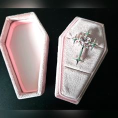 an empty pink box with a cross on the front and back side, sitting on a black surface