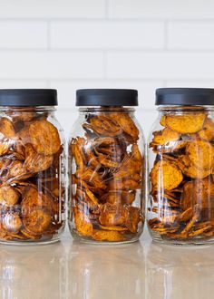 three glass jars filled with food sitting on top of a counter