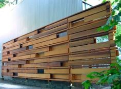 a building made out of wooden slats sitting on the side of a road next to trees