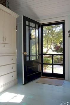 an open door leading into a room with white walls and flooring on either side