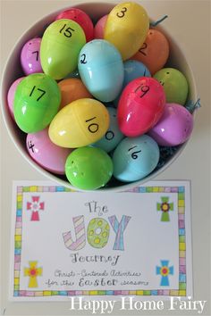 a bowl filled with lots of colorful eggs next to a happy home fairy sign on the table