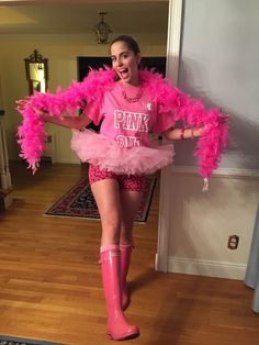 a woman in pink is standing on the floor wearing rain boots and a pink shirt