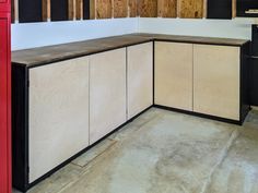 an unfinished kitchen with black and white cabinets