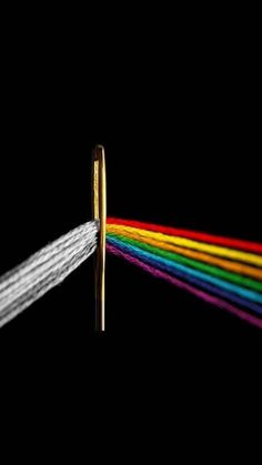 an image of a rainbow colored light coming out of a pipe with gold tips on black background