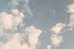 an airplane is flying in the sky with white clouds behind it and blue skies above