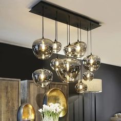 a chandelier hanging from the ceiling in a room with black walls and gold accents