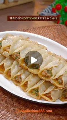 a white plate topped with dumplings covered in meat and sauces on top of a woven table cloth