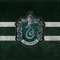 the slys crest is on top of a green knitted sweater with white stripes