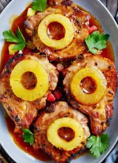 a white plate topped with chicken covered in pineapples and garnishes