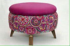 a pink ottoman sitting on top of a wooden stand