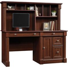 an office desk with a computer monitor and bookshelf on it's side