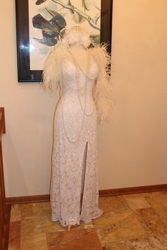 a white dress with feathers and pearls on display