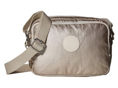 a metallic purse with a white circle on the front and tan strap around it's shoulder