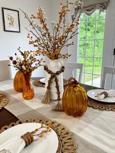 the table is set with dishes and vases