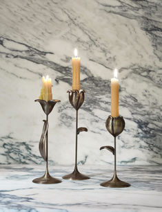 Set of three bronze floral candlesticks