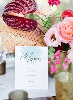 a table setting with flowers and menu cards