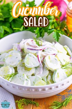 a white bowl filled with cucumber salad on top of a wooden table