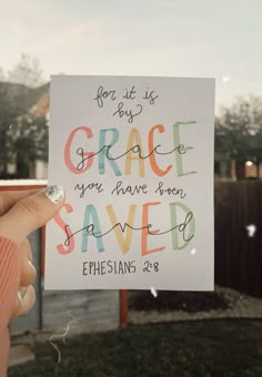 someone holding up a sign that says grace you have been saved ephesians 28