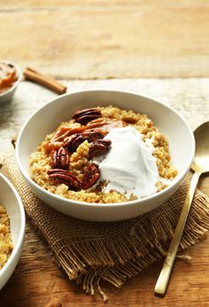 two bowls filled with oatmeal and pecans on top of a wooden table