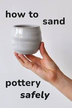 a hand holding a white pottery vase with the words how to sand written on it