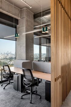 an office with large windows and wooden partitions on the wall, along with black chairs